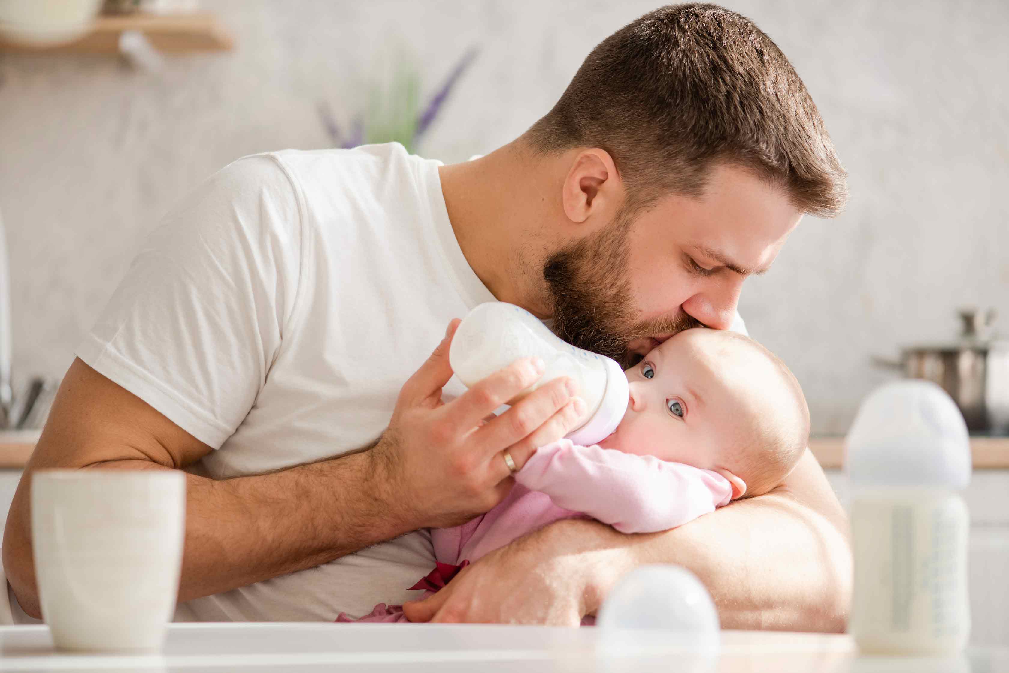 Dad bottle feeding baby