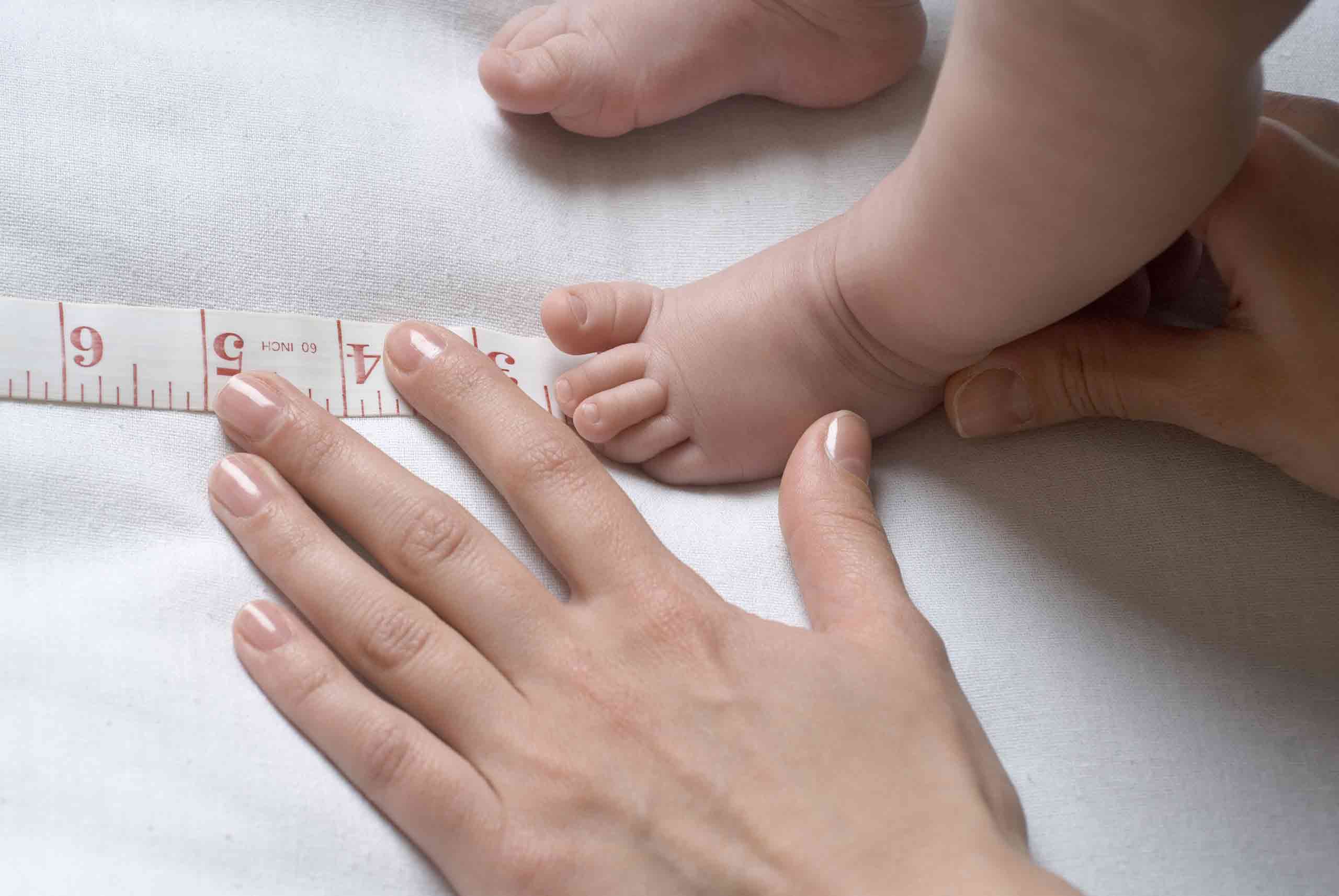 Mom measuring baby's feet