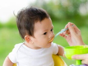 Mom feeding baby in a chair