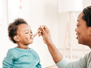 Bébé mange un laitage au fromage blanc. 