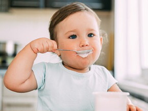 Bébé mange un laitage au fromage blanc