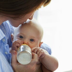 Bébé boit son biberon avec des légumes
