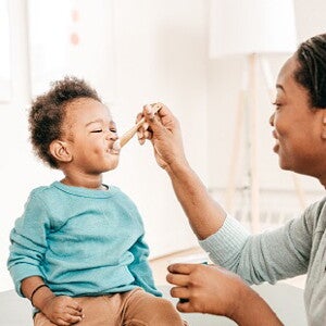 Bébé mange un laitage au fromage blanc. 