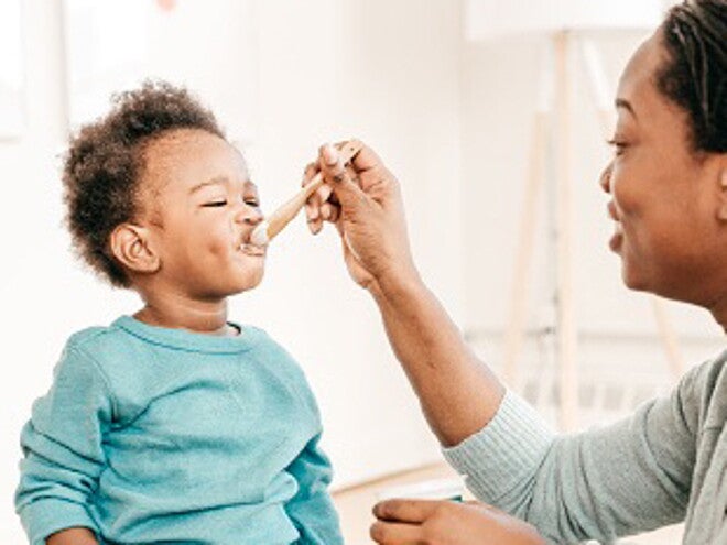 Bébé mange un laitage au fromage blanc. 