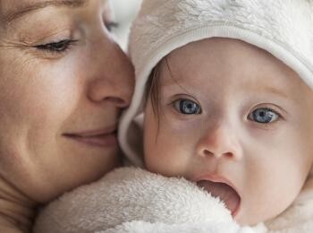 Mom holding baby smiling