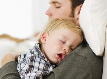 Baby sleeping in dad's hands