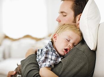 Baby sleeping in dad's hands