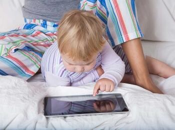 Baby exploring tablet with mom