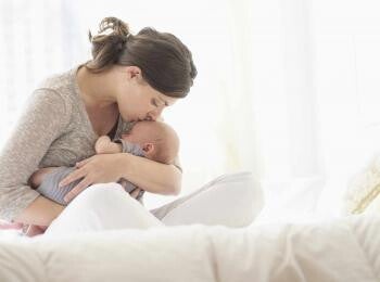 Mom holding and kissing her baby