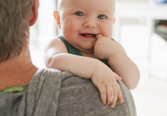 baby smiling on father hands